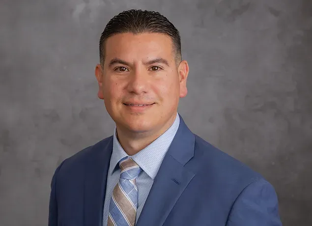 A man in a suit and tie is smiling for the camera.