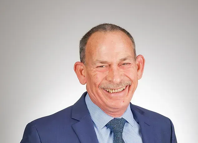 A man in a suit and tie is smiling for the camera.