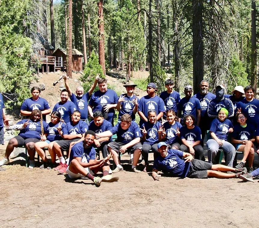 A group of people posing for a picture in the woods