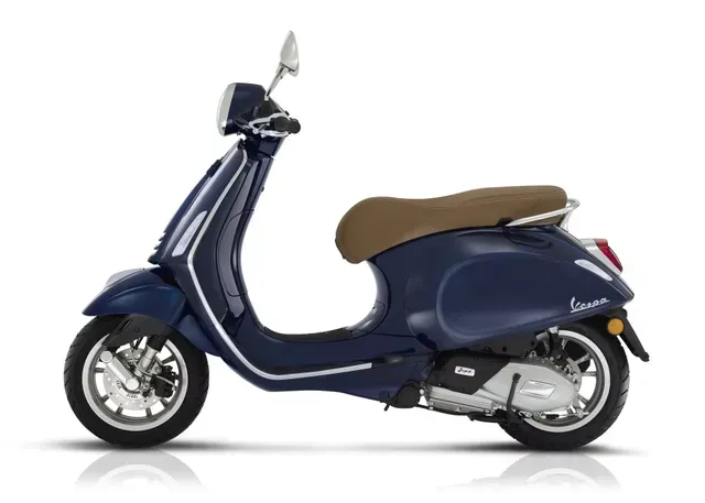 Scooter blu con sella color cuoio, vista laterale su sfondo bianco