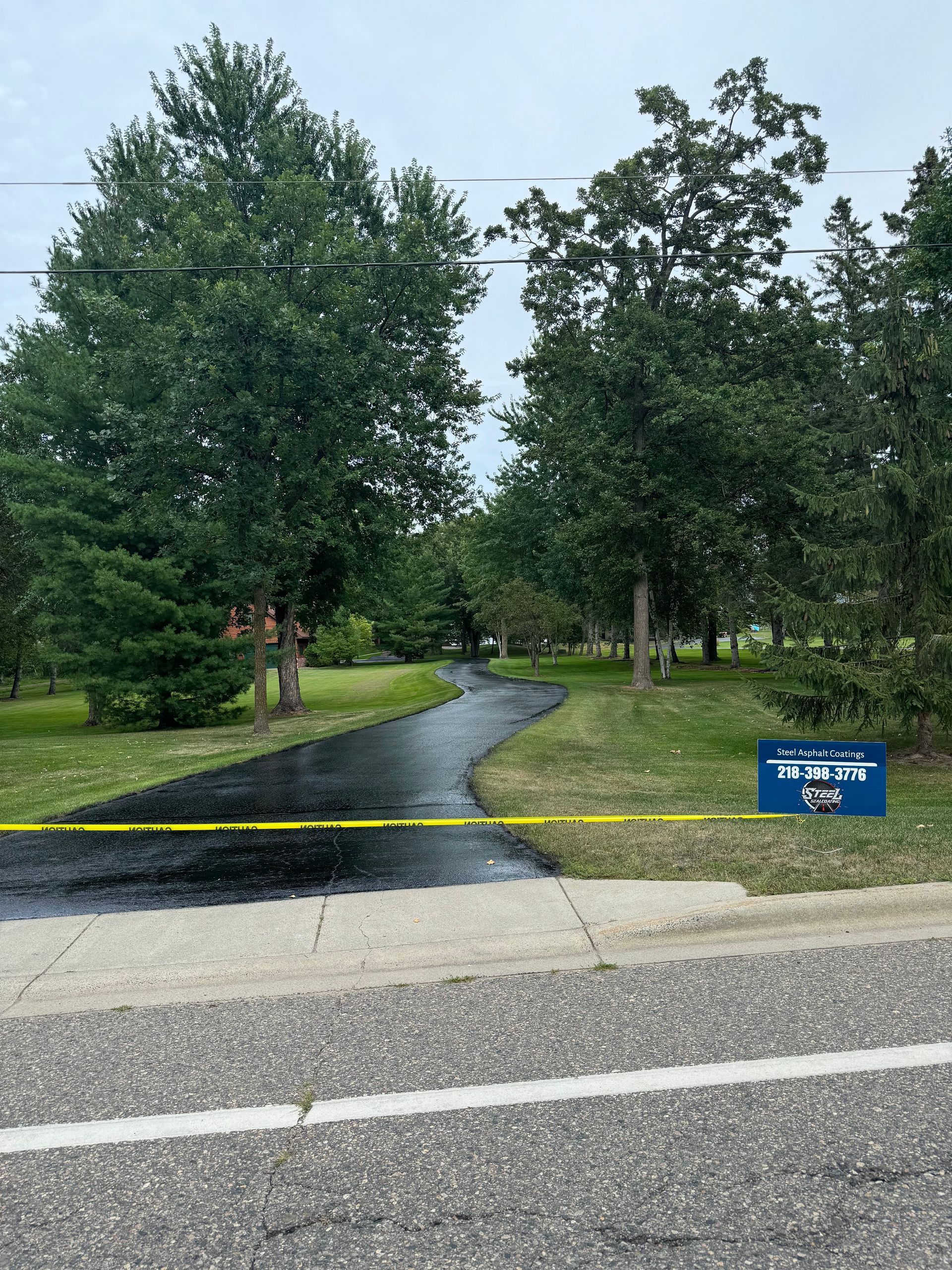 A road with a sign on the side of it and trees on the side of it.