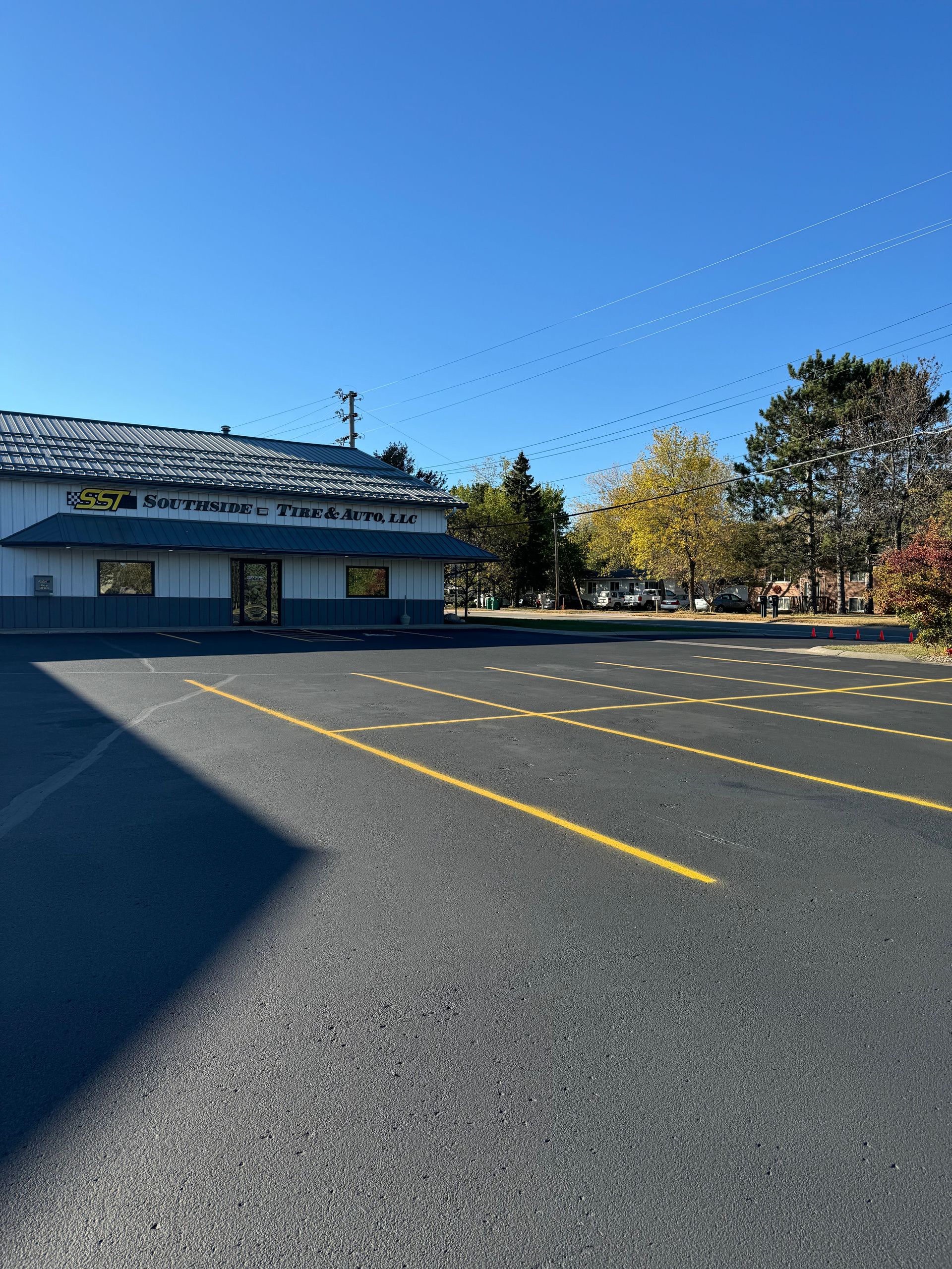 A parking lot in front of a building with a blue sky in the background.