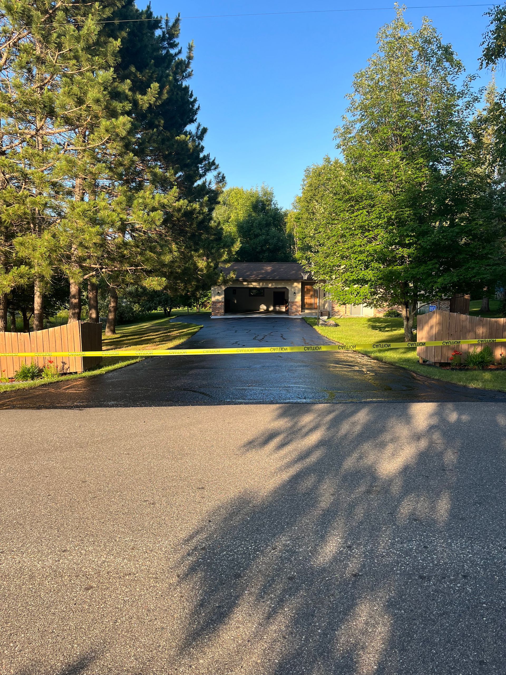 A driveway leading to a garage surrounded by trees