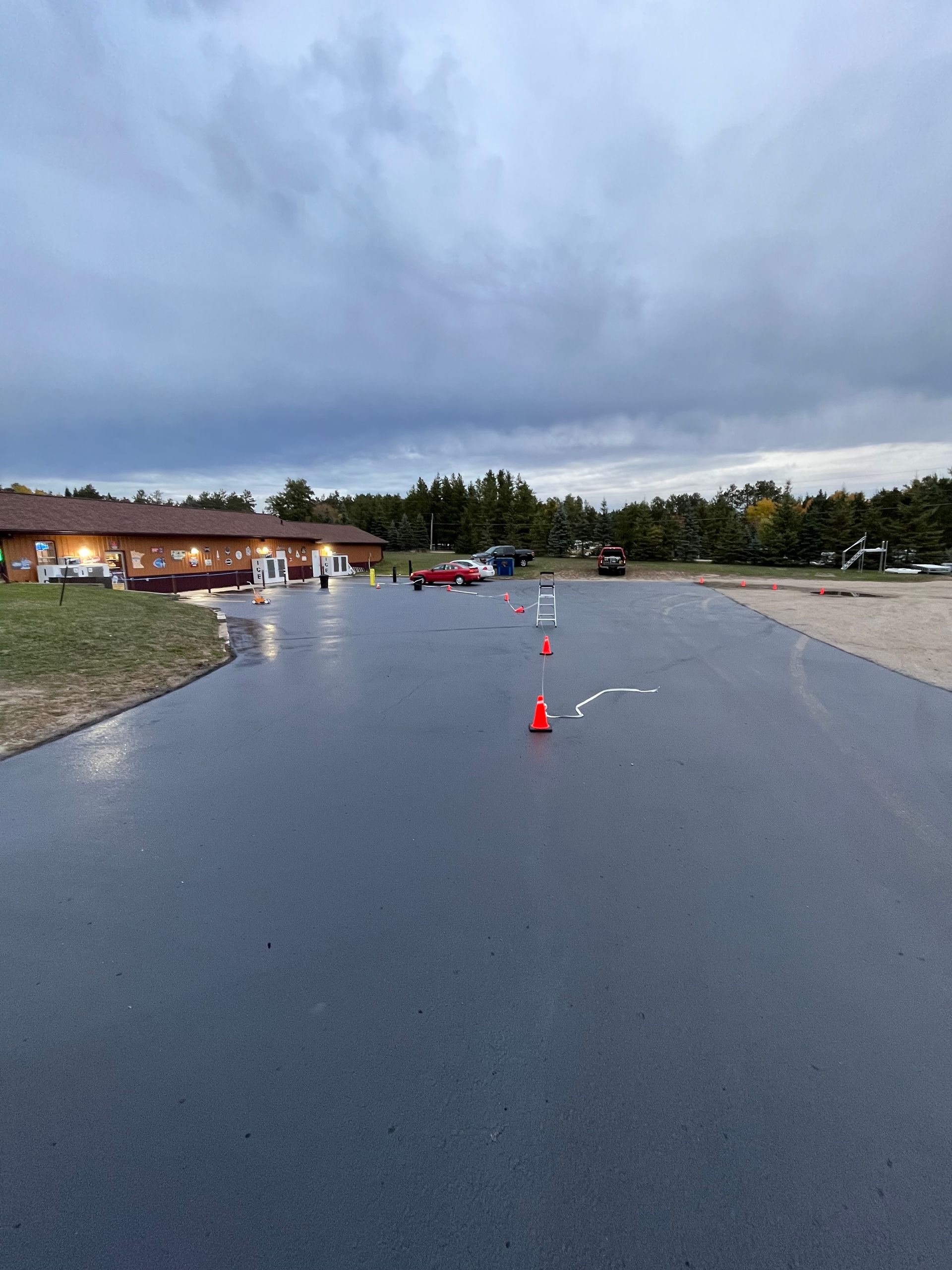 A parking lot with cars parked in it and a building in the background.