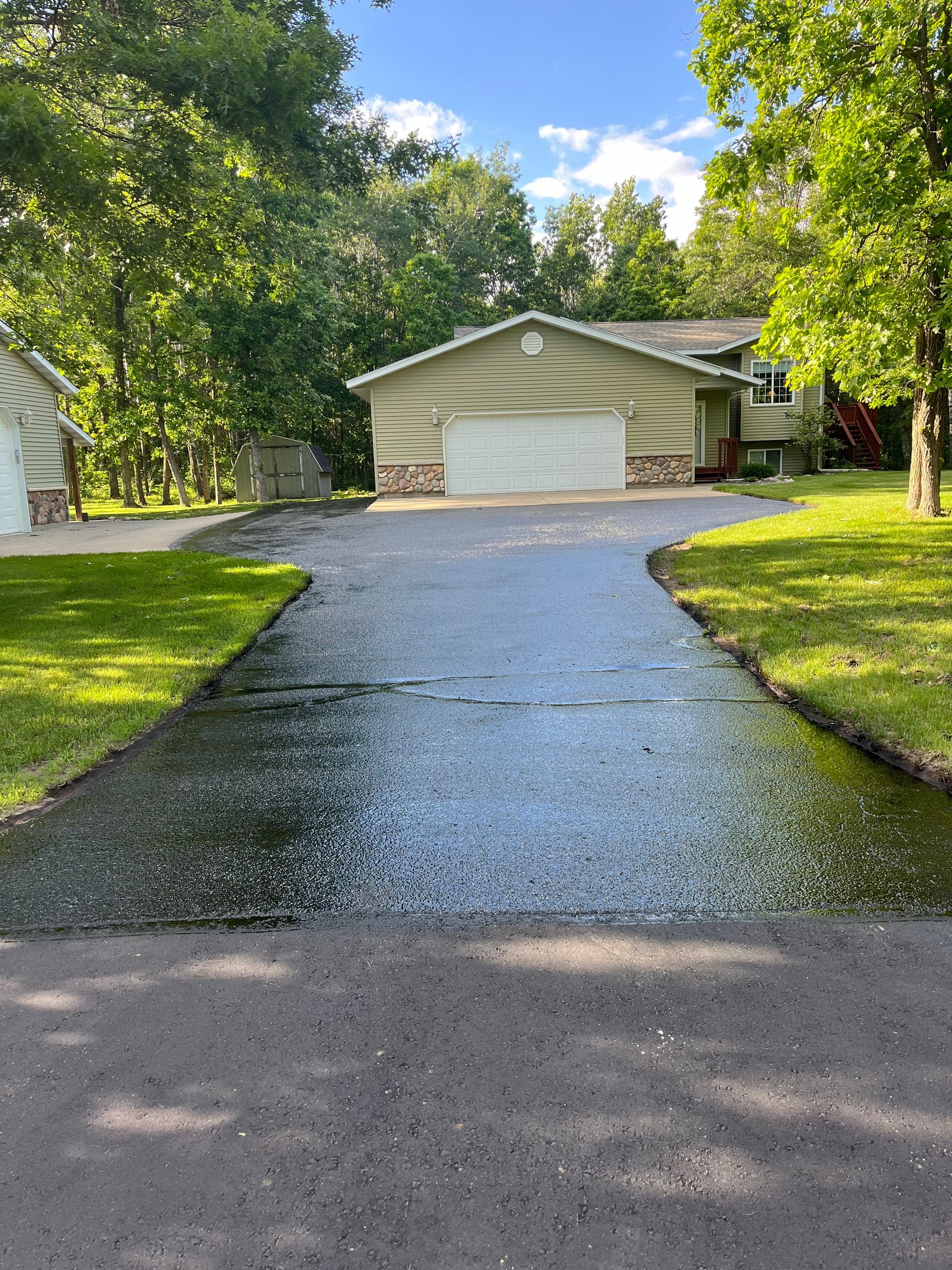 A driveway leading to a house with a garage.
