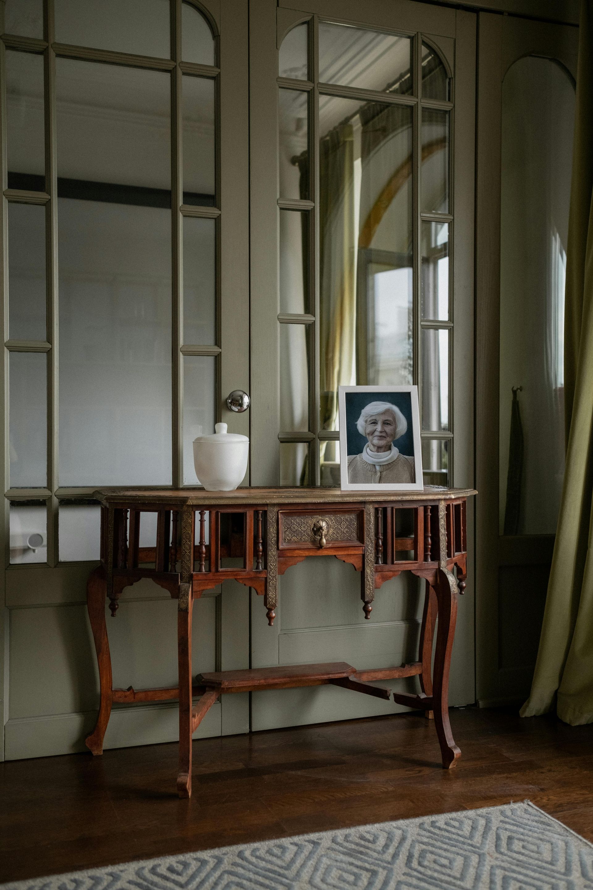 Two pairs of hands clasped together on a table, conveying comfort and support.