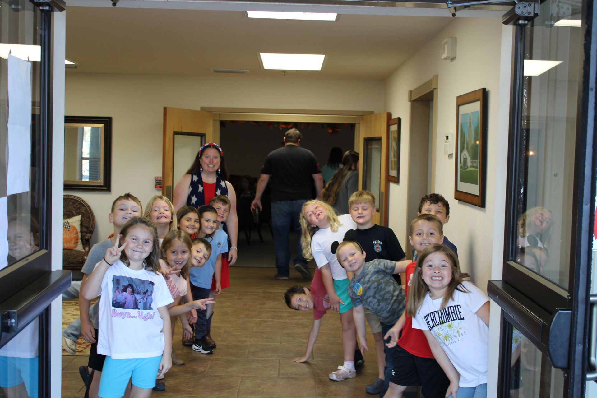 A group of children are posing for a picture in a hallway