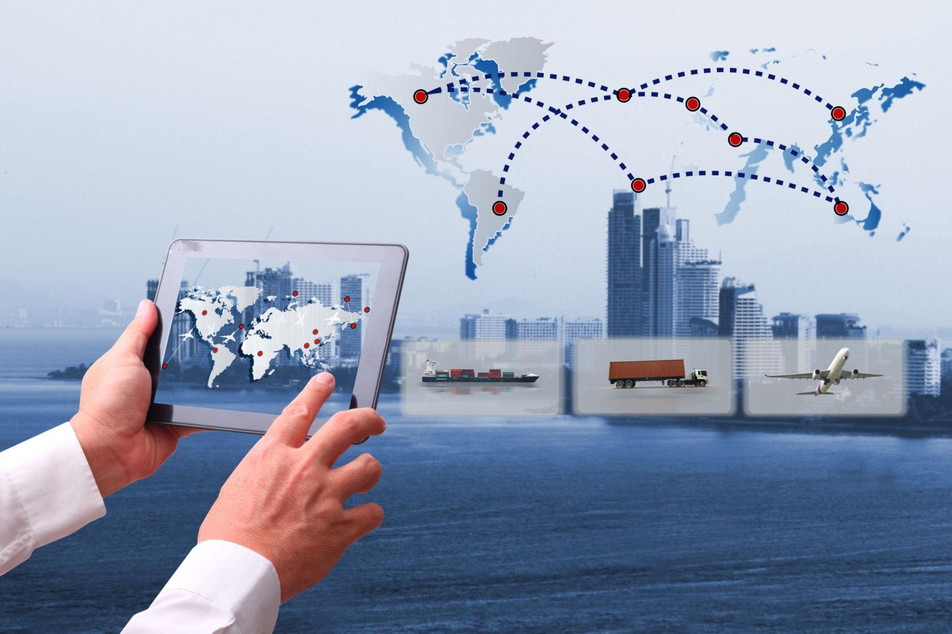 Hands using a tablet with a world map and connected global shipping routes over a city waterfront.