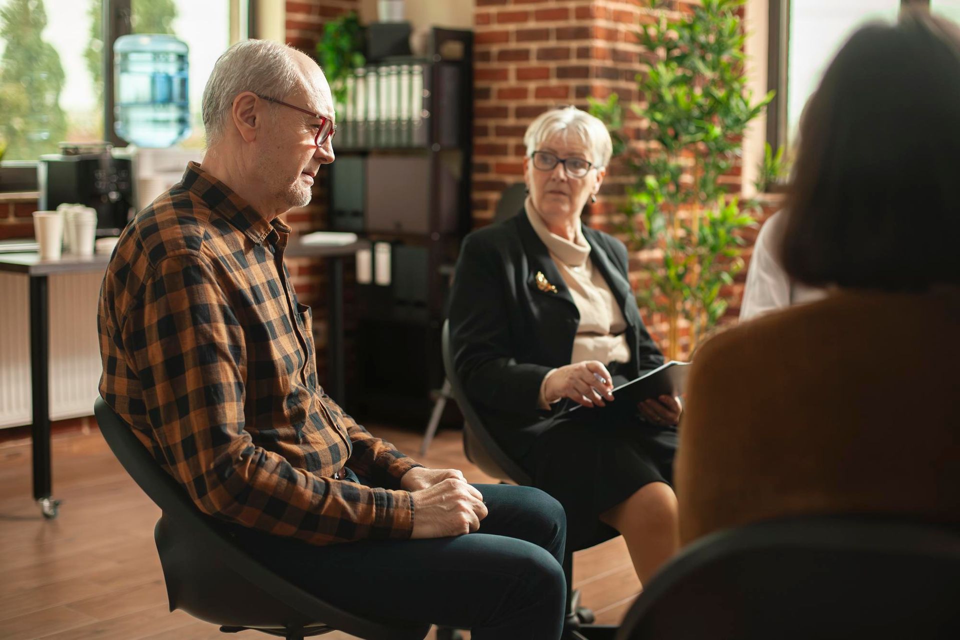 People seated in a sunlit room during a small group discussion