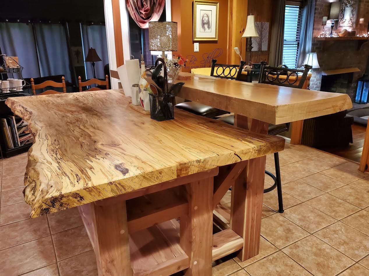 Two wooden kitchen islands, one with a live edge, brown tones, and rustic design.