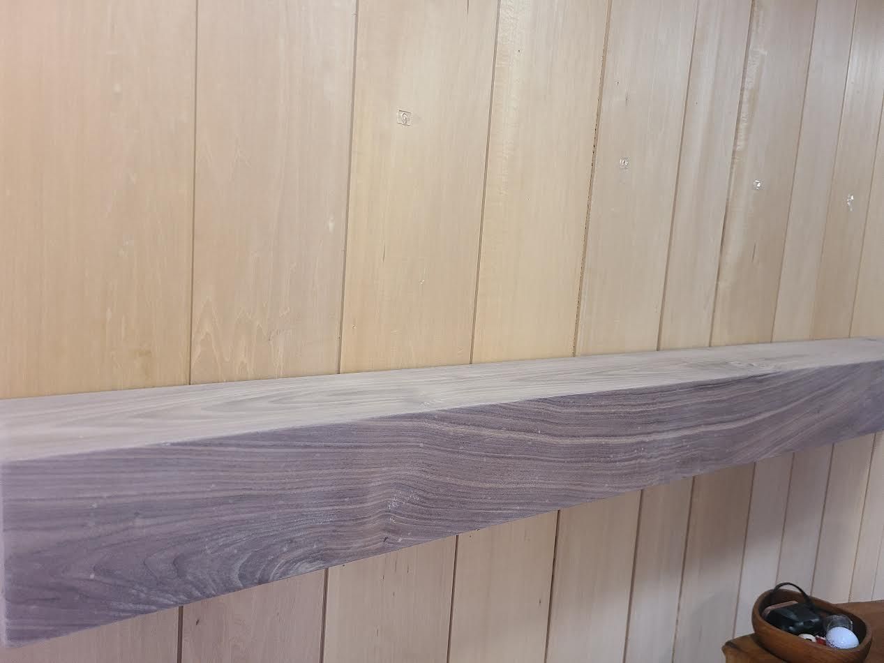 Wooden shelf against a light-colored wooden wall.