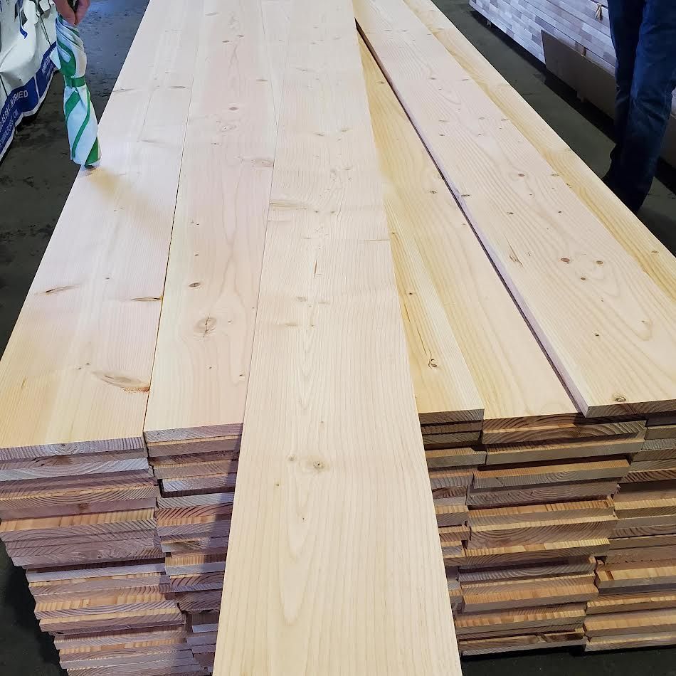 Stack of light-colored wooden planks, likely for construction.