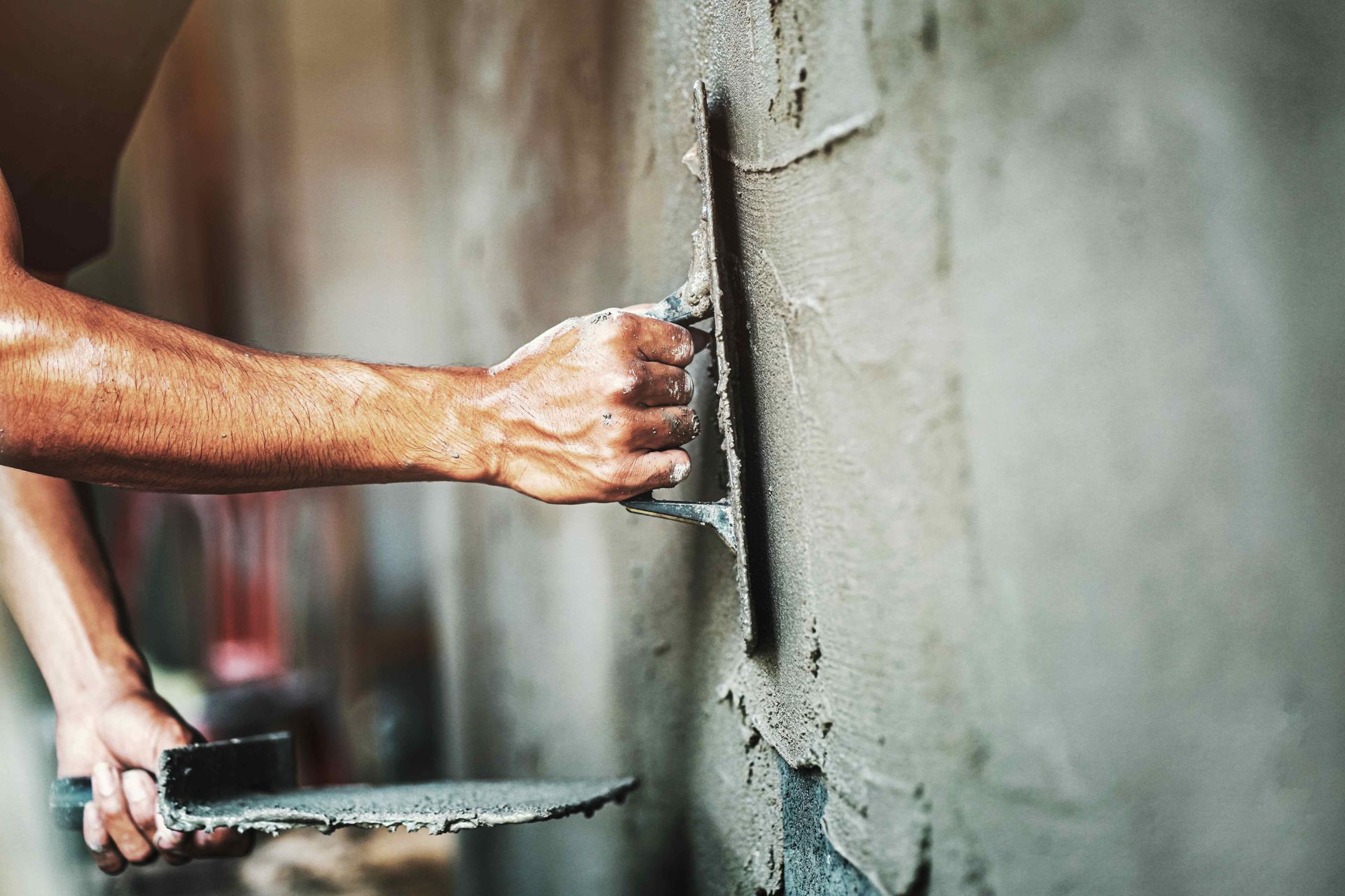 a man is plastering a wall with a trowel
