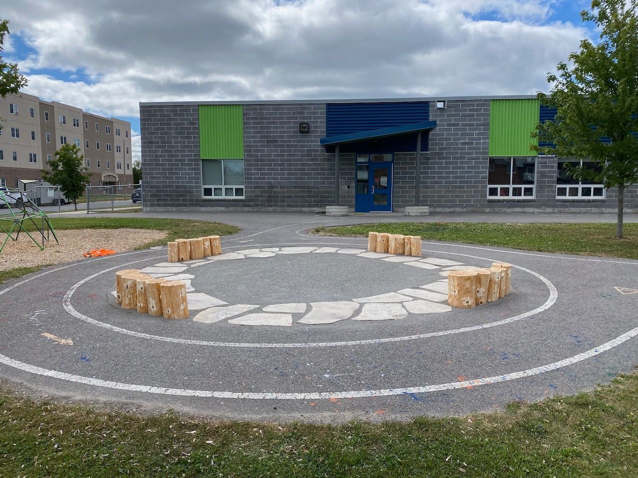 School building exterior with seating area made of stone and wood blocks.