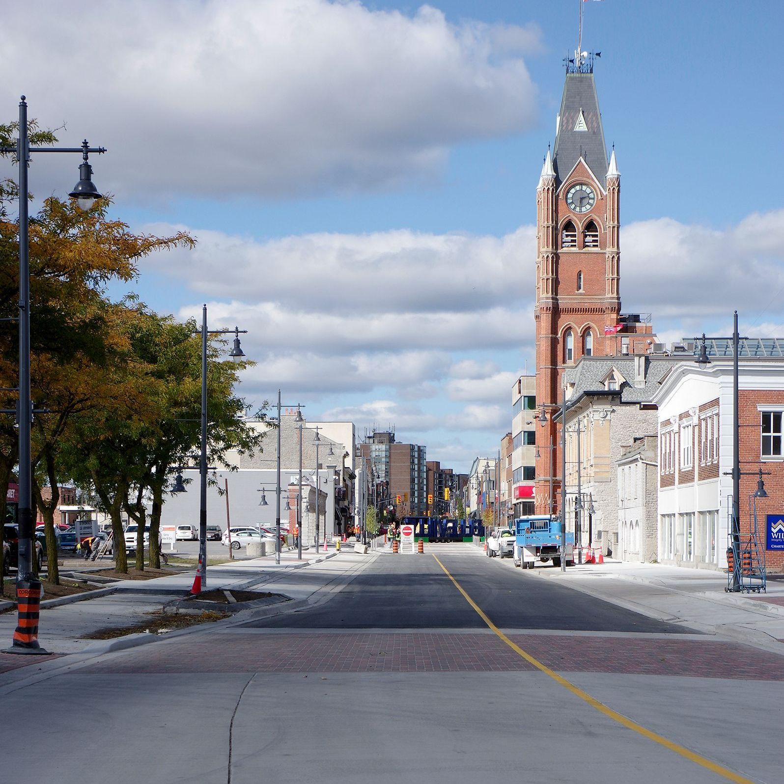 A city street with a large clock tower in the background