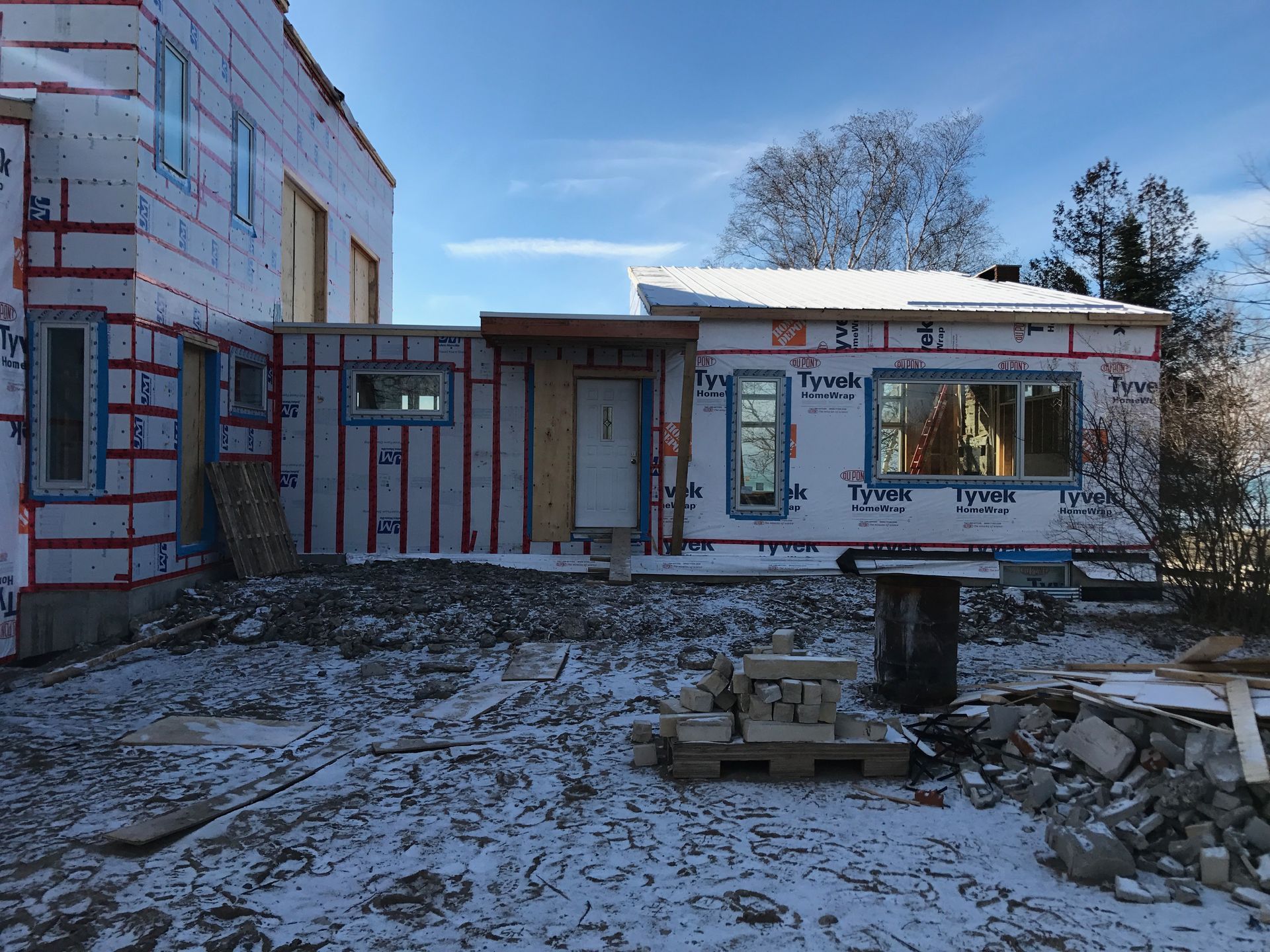 A house is being built in the snow with a lot of windows.