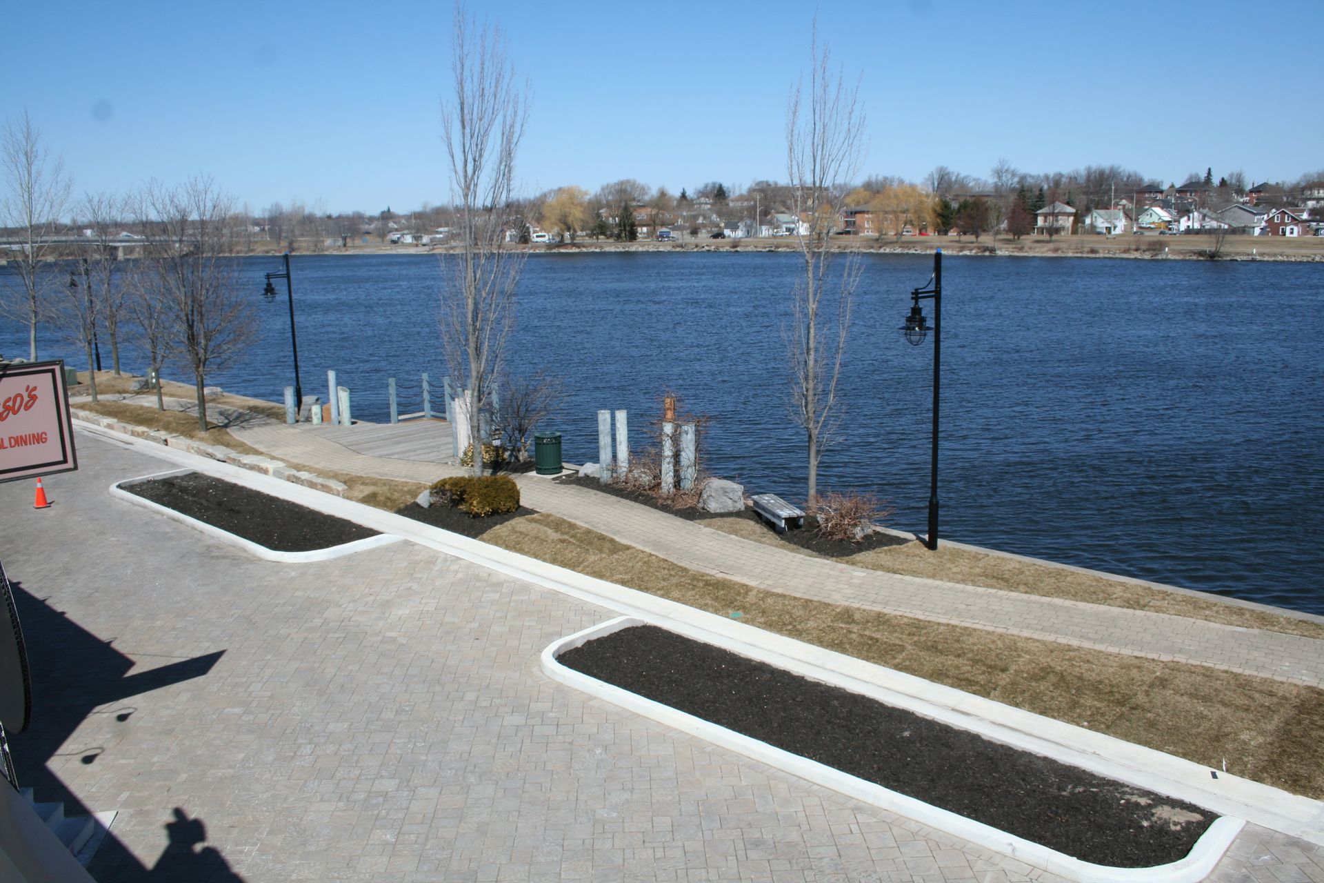 A parking lot next to a body of water with a sign that says no parking
