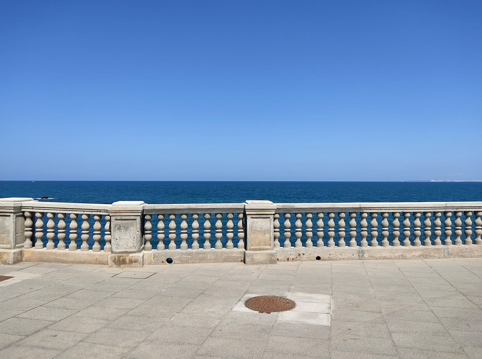 A stone fence overlooking the ocean on a sunny day