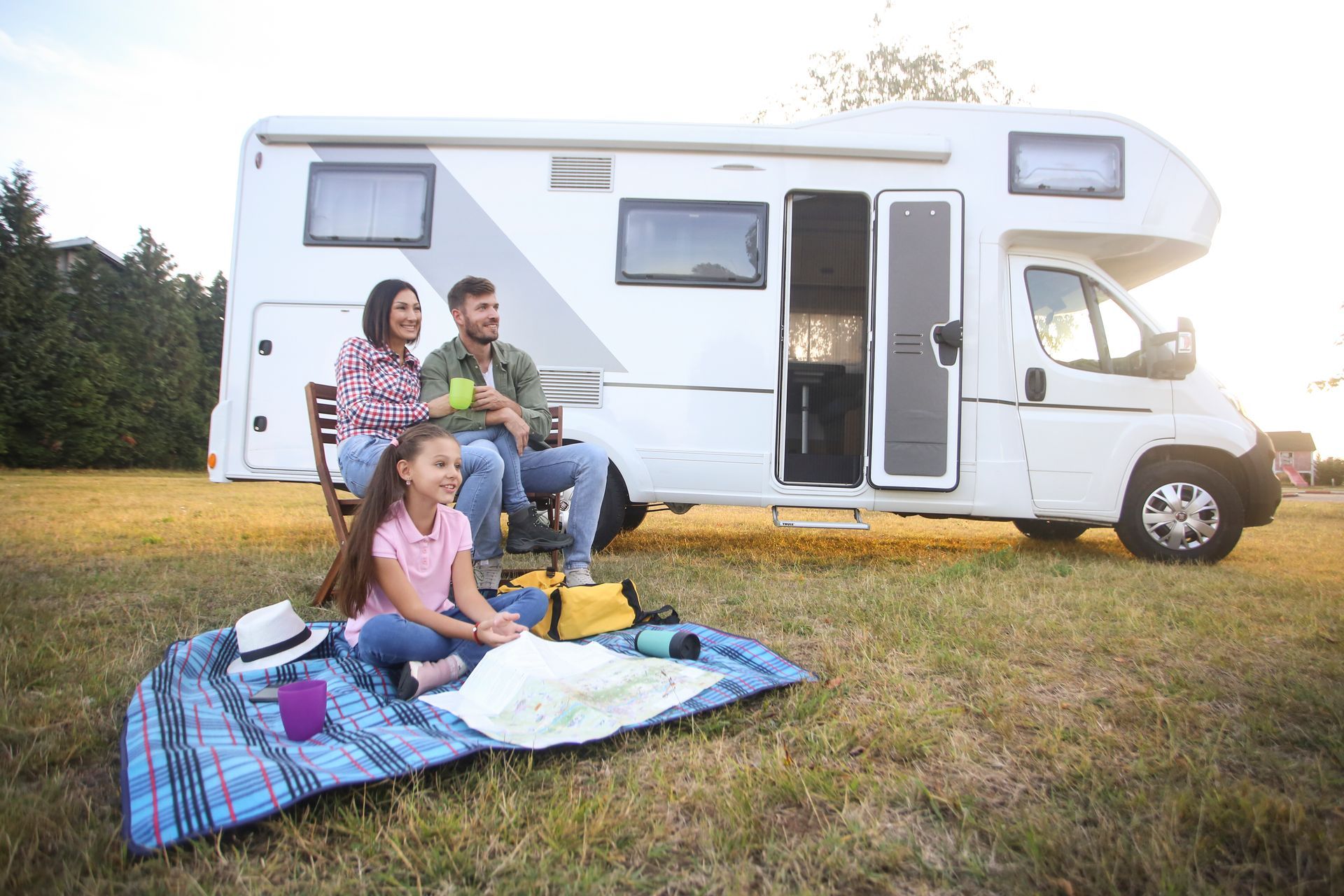 Family camping with a recreational vehicle in the background