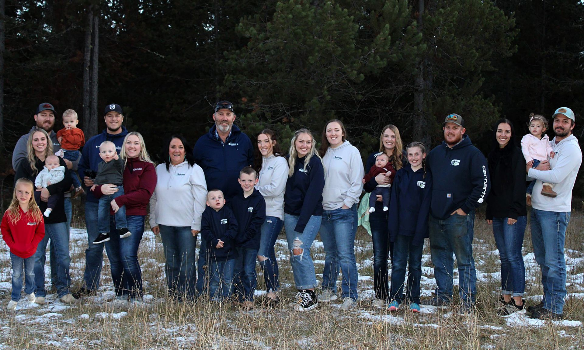 A large family is posing for a picture in the snow.