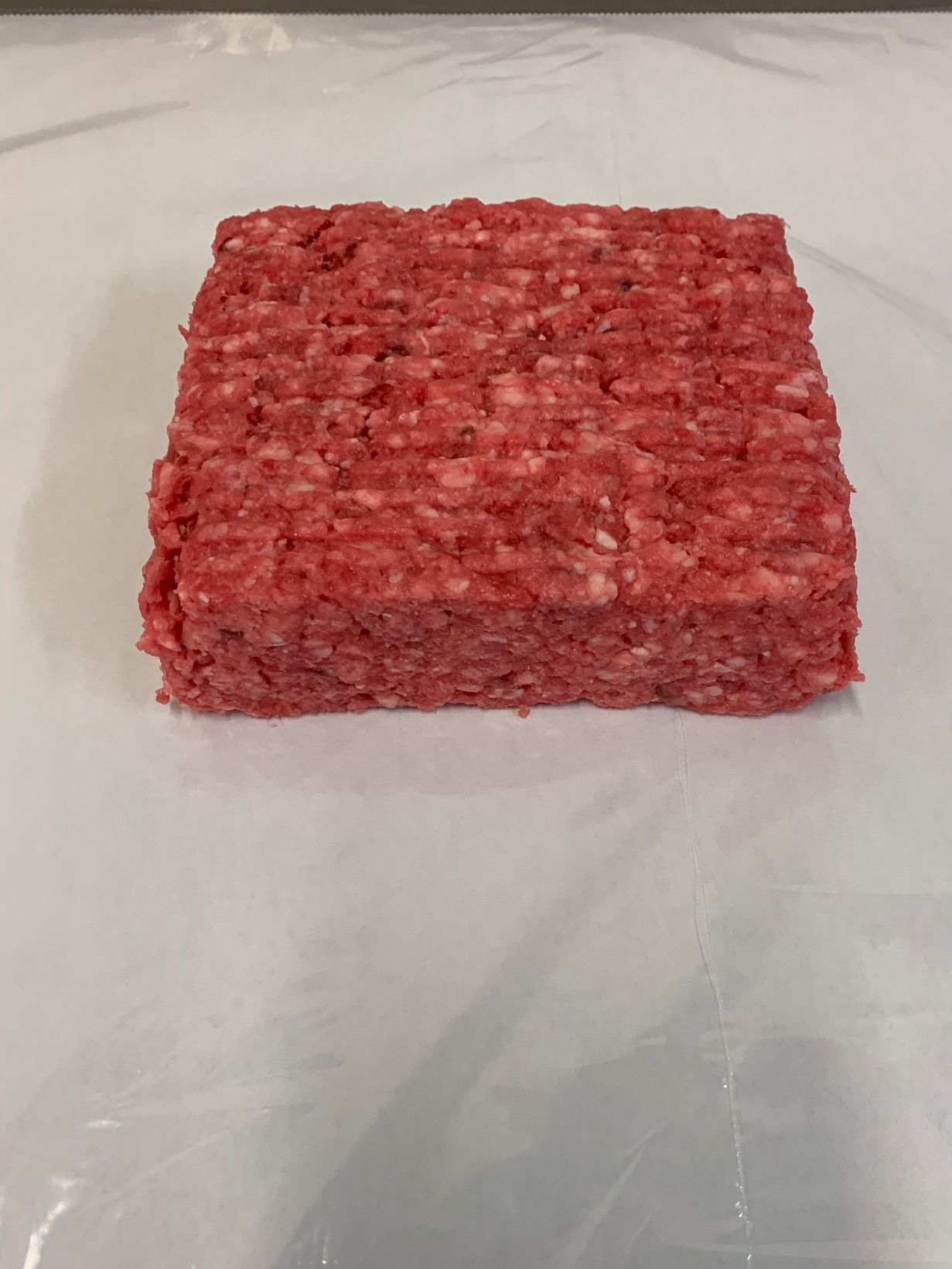 A piece of ground beef is sitting on a white surface.