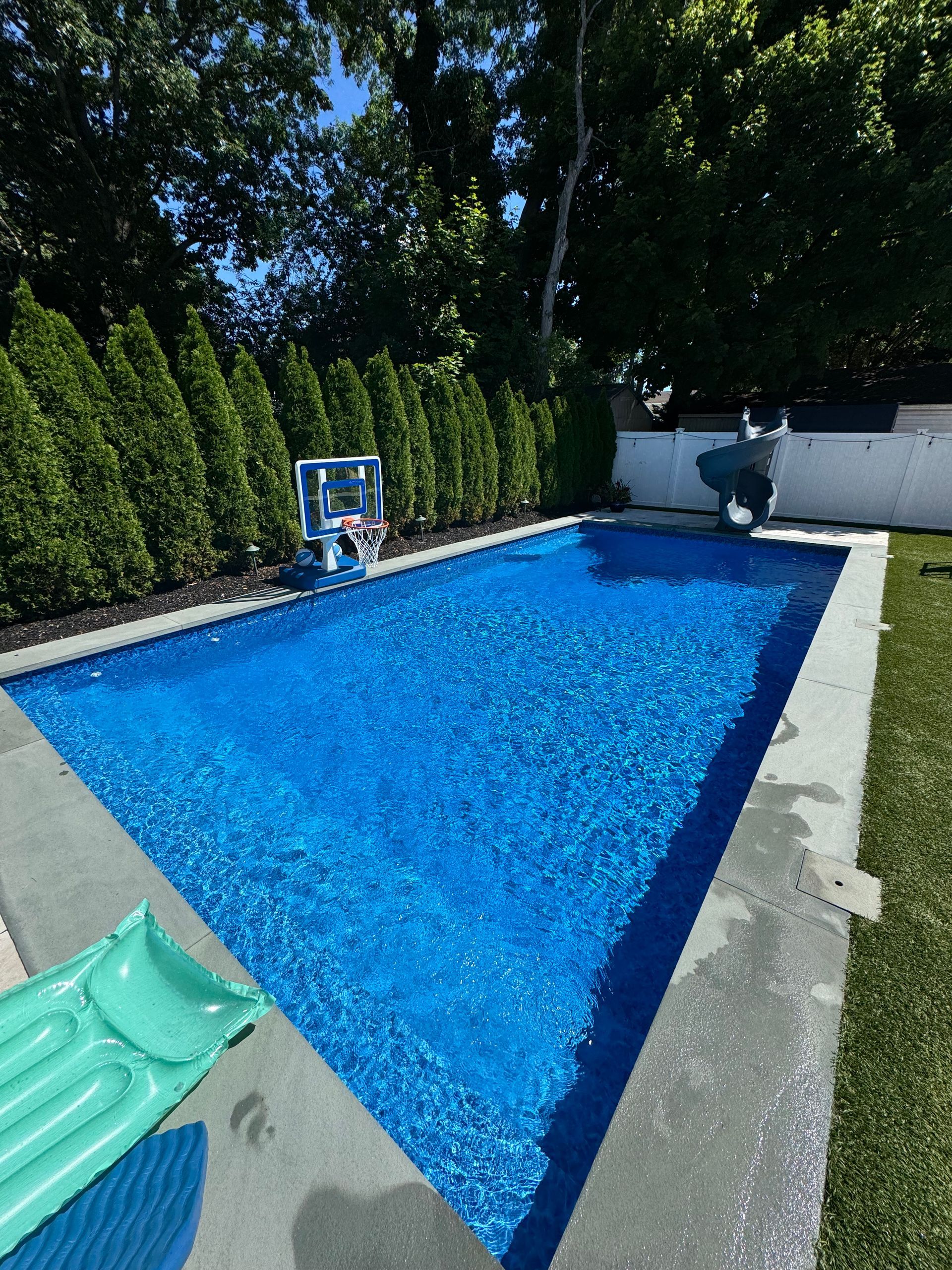 A woman 's legs are sticking out of a swimming pool.