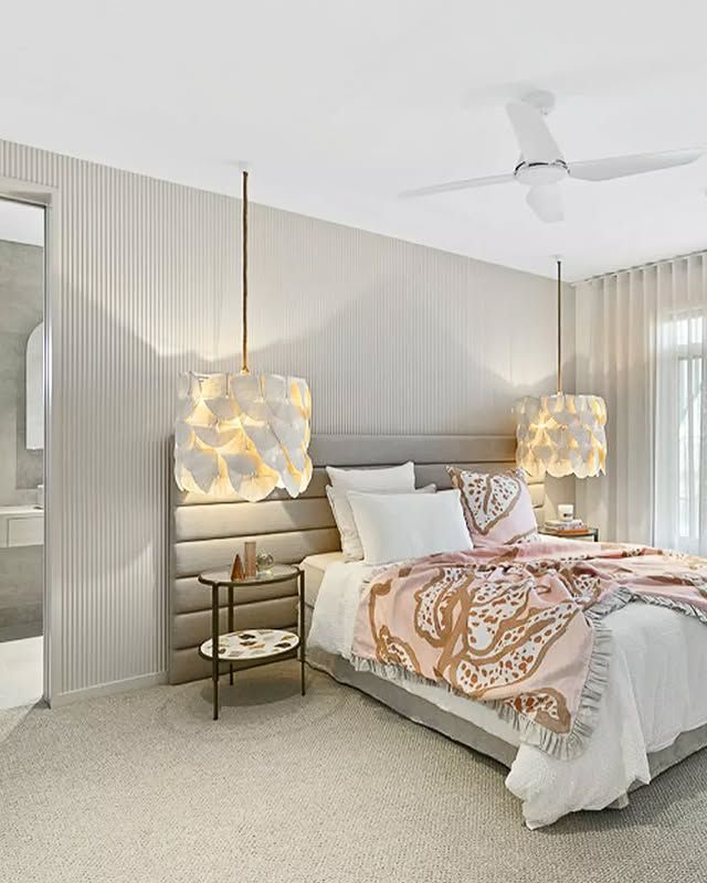 Bedroom with pendant lights, neutral tones, a bed with pink throw, and a small side table — L & K Electrical & Air Conditioning in Narrabri, NSW