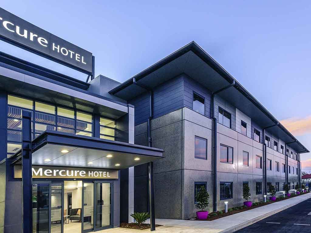 Mercure Hotel exterior with modern architecture; grey and white facade, entrance canopy, sign, and plants — L & K Electrical & Air Conditioning in Tamworth, NSW