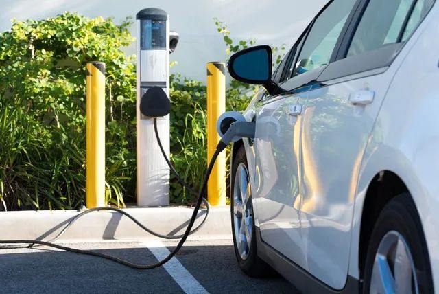An Electric Car is Being Charged at a Charging Station — L & K Electrical & Air Conditioning in Scone, NSW