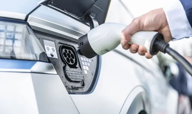 A Person is Charging an Electric Car With a Charger — L & K Electrical & Air Conditioning in Narrabri, NSW
