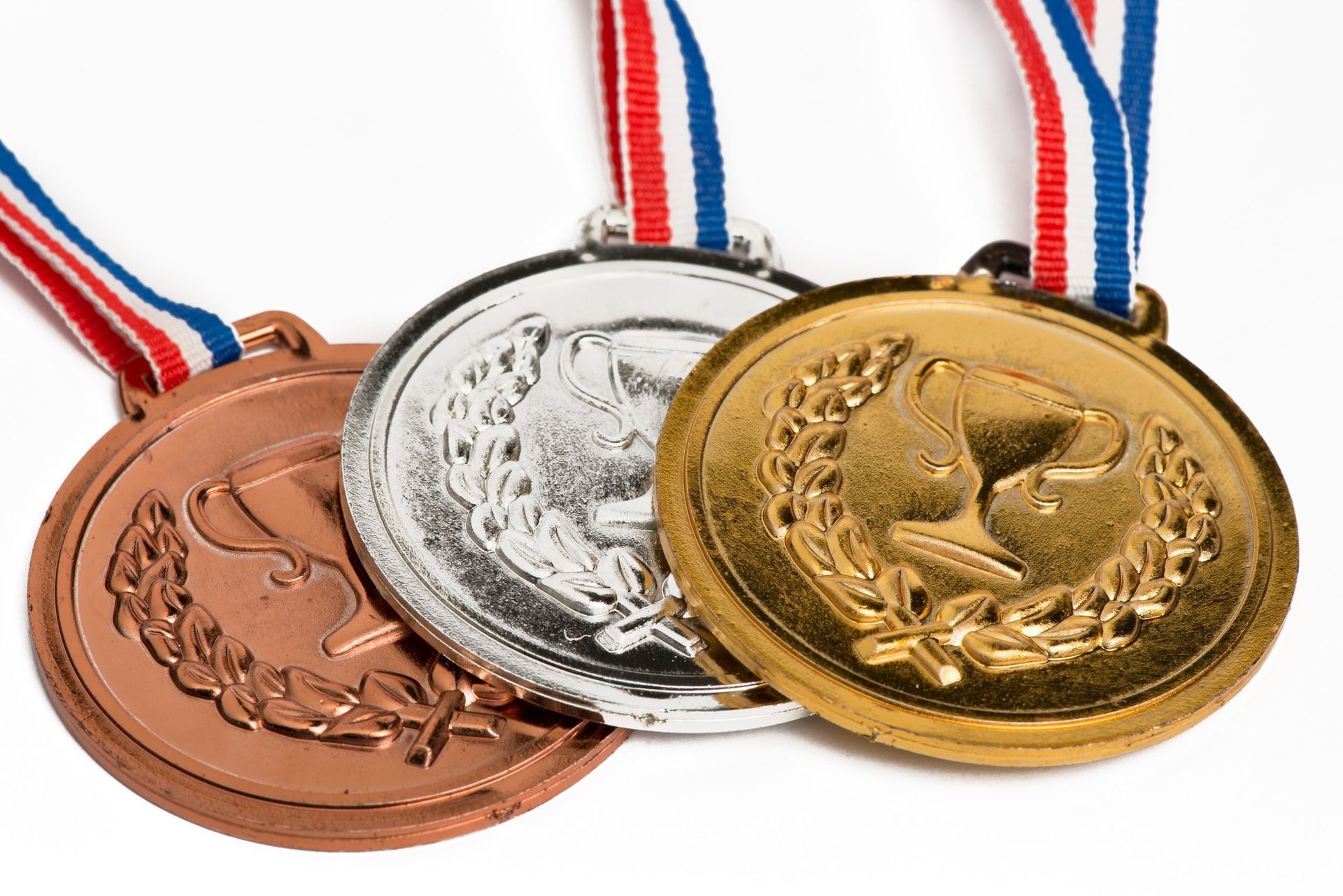 Three medals are stacked on top of each other on a white background