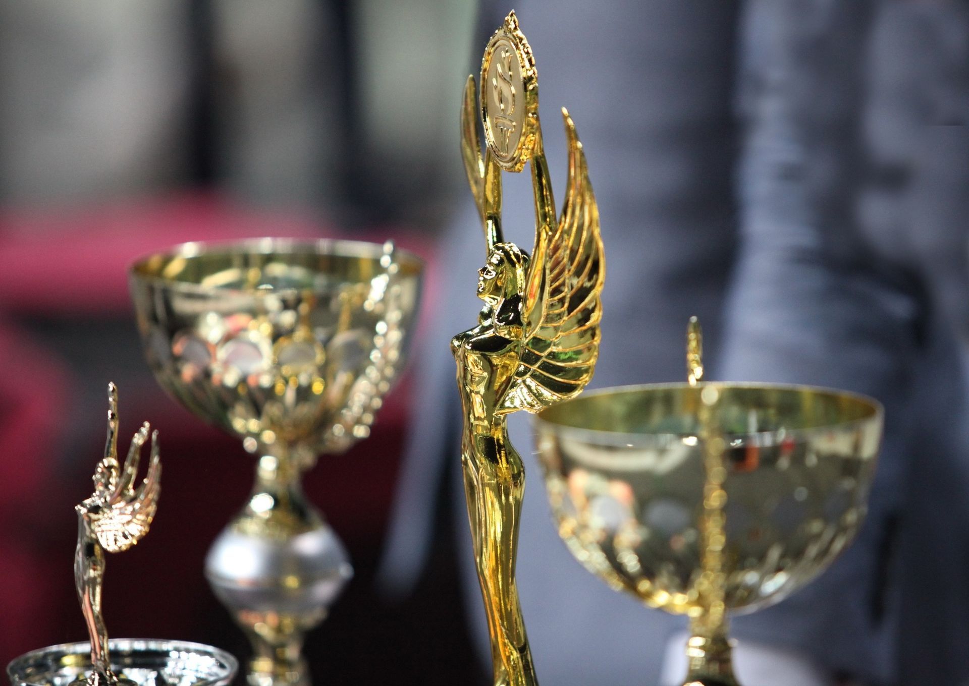 Three gold trophies are sitting on a table