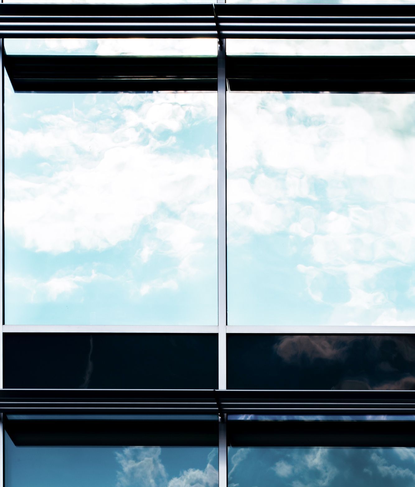 The sky is reflected in the windows of a building.