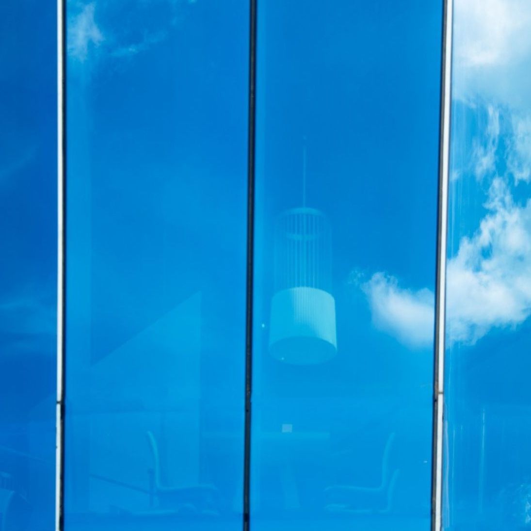 A blue sky is reflected in the windows of a building.
