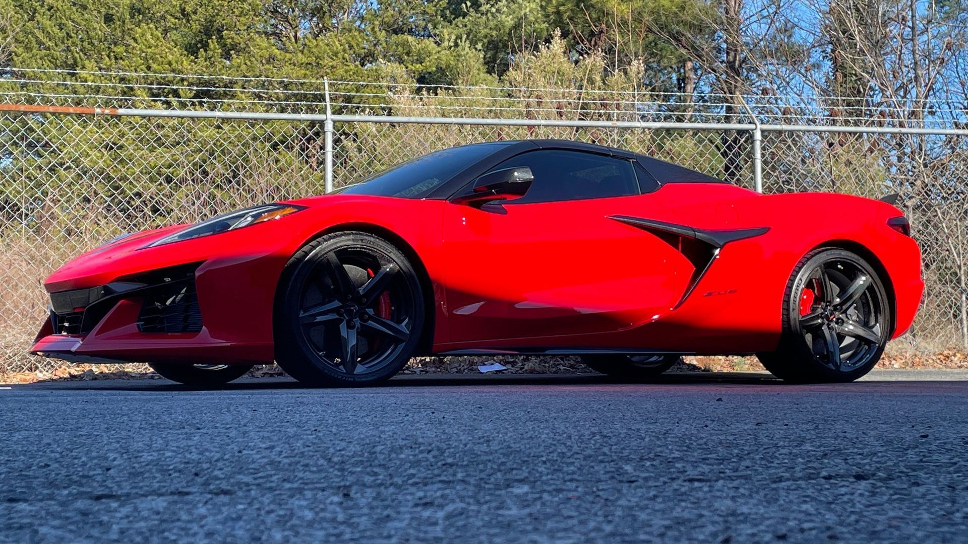 A red sports car is parked on the side of the road.
