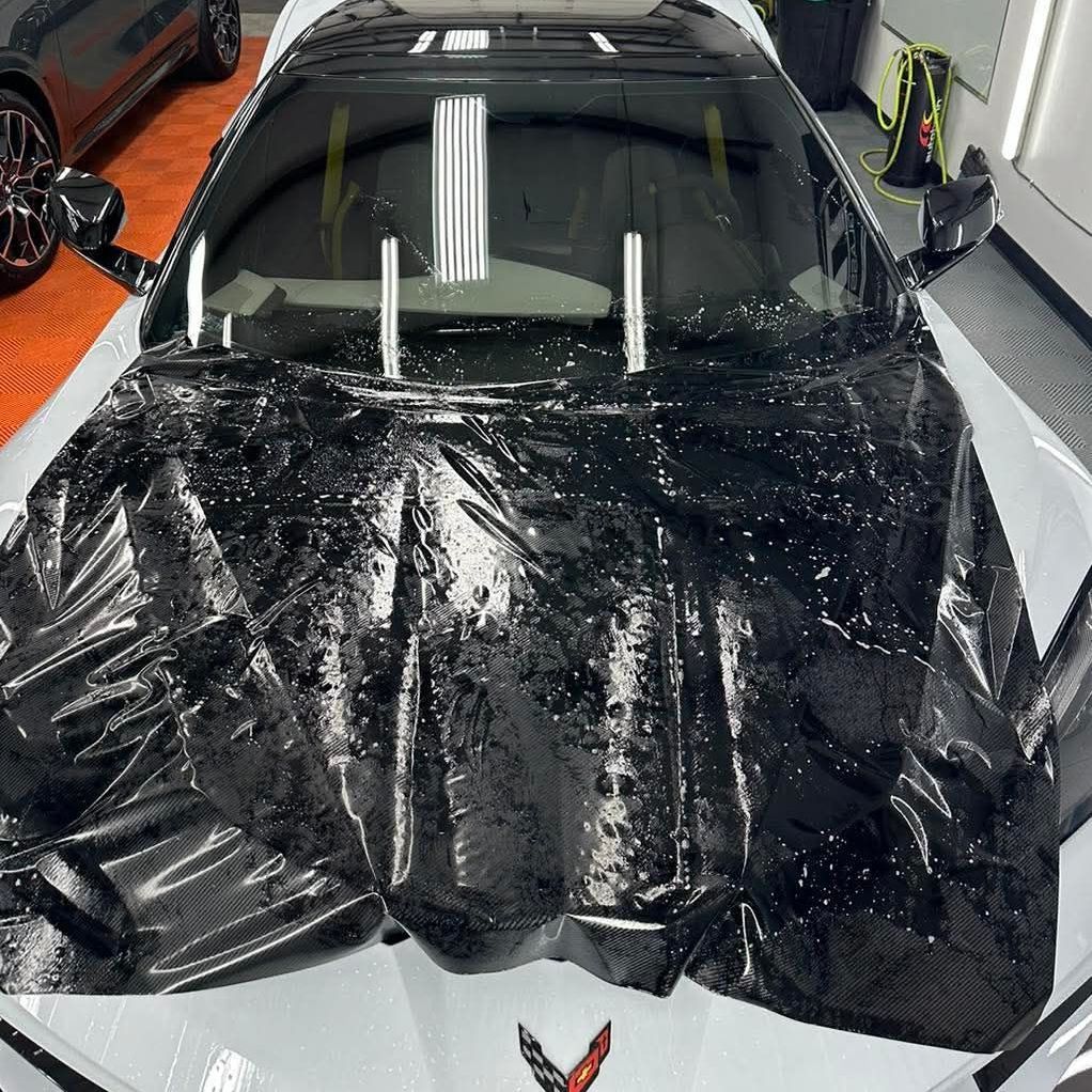 A white corvette sports car is parked in a garage.