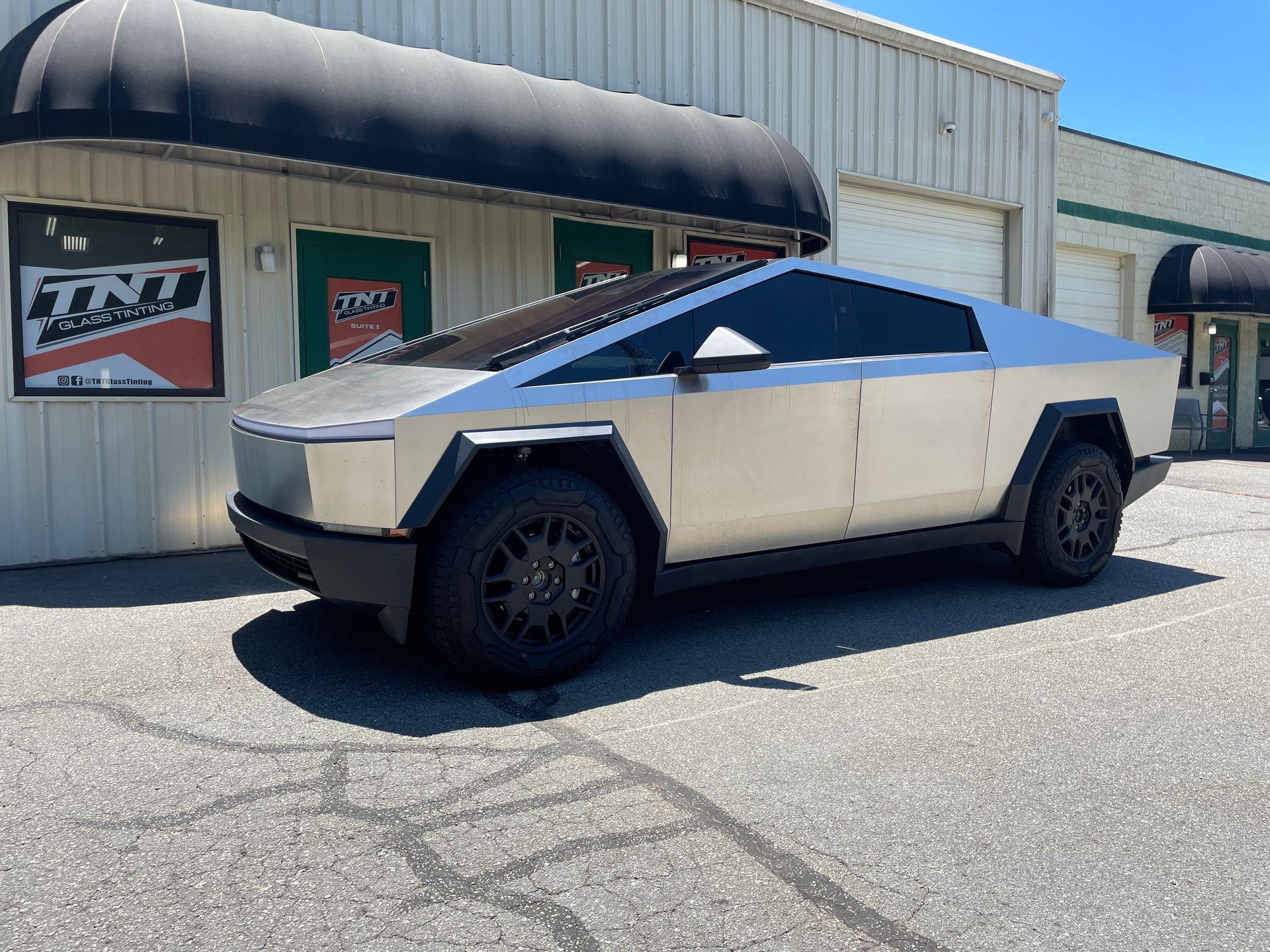 A green lamborghini urus is parked in front of a building.