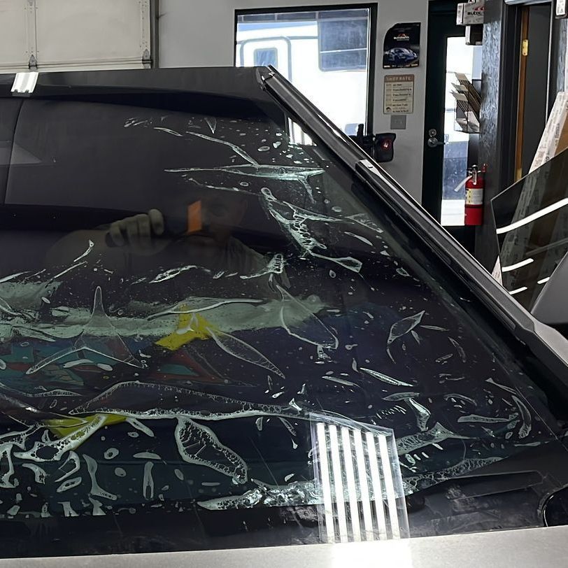 A car with a broken windshield is sitting in a garage.