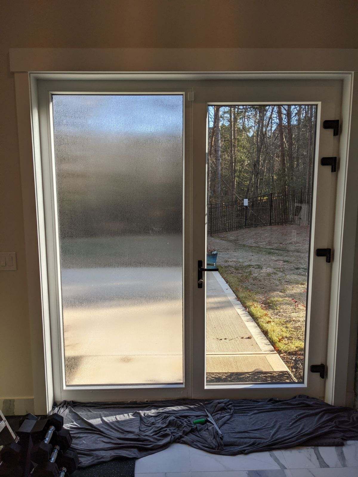 A sliding glass door in a room with a view of a yard.
