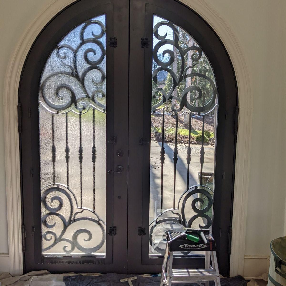 A wrought iron door with a ladder in front of it