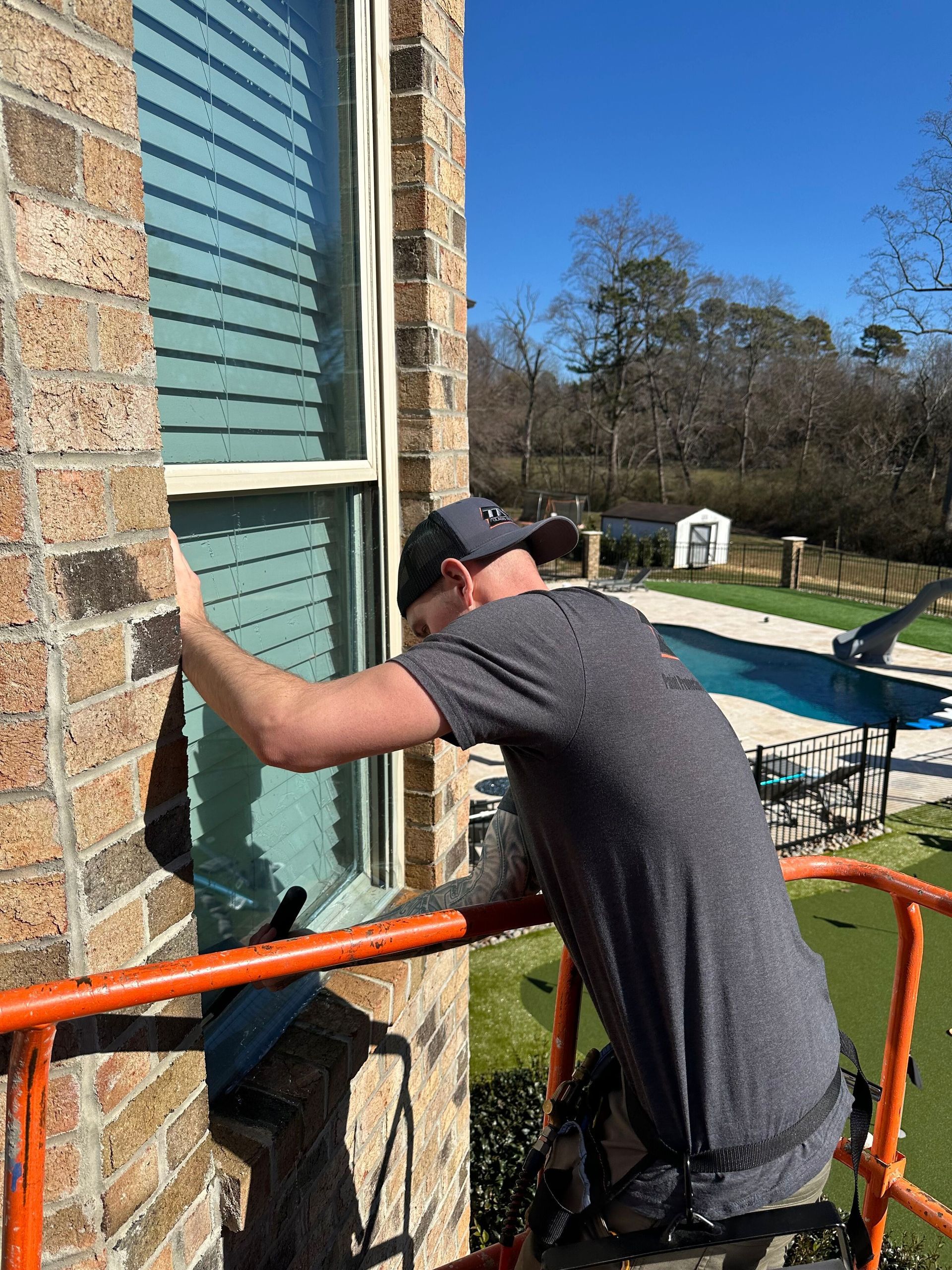 A man is working on a window on a scaffolding.