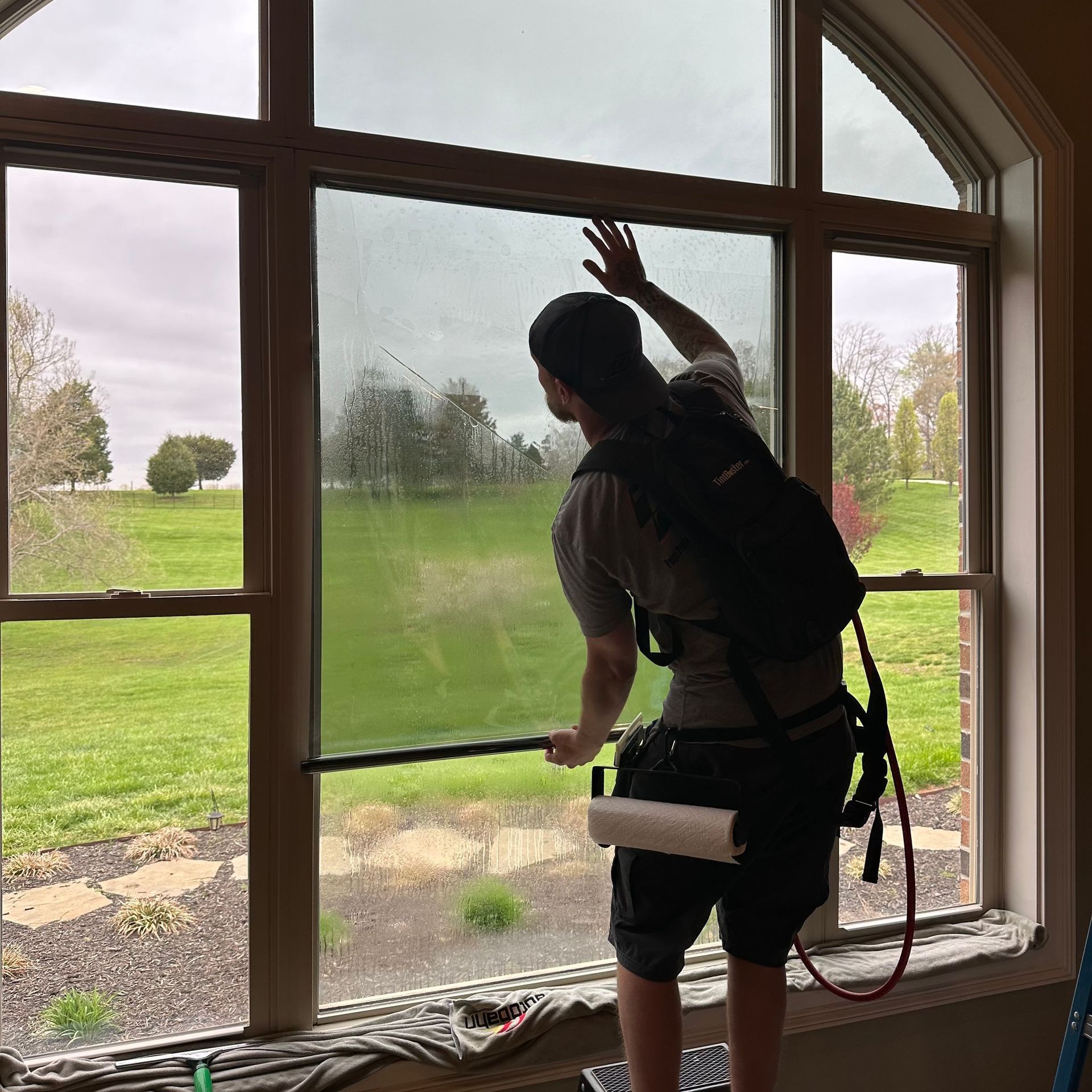 A man is cleaning a window with a squeegee.