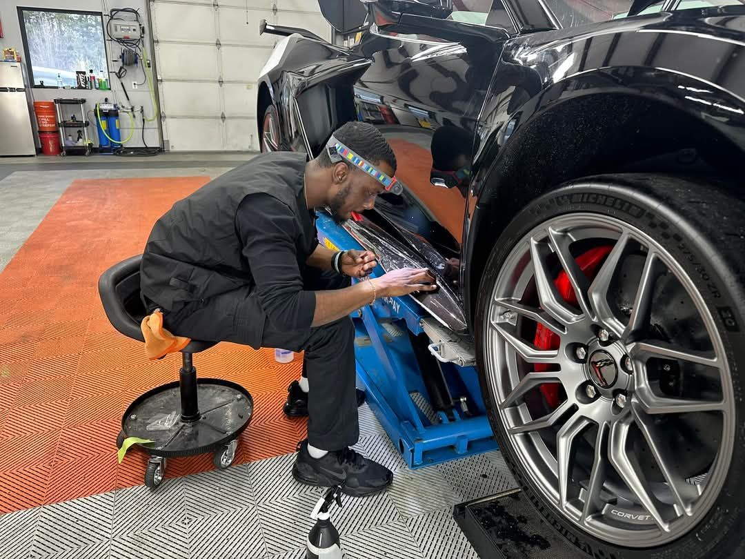 A man is working on a car in a garage.
