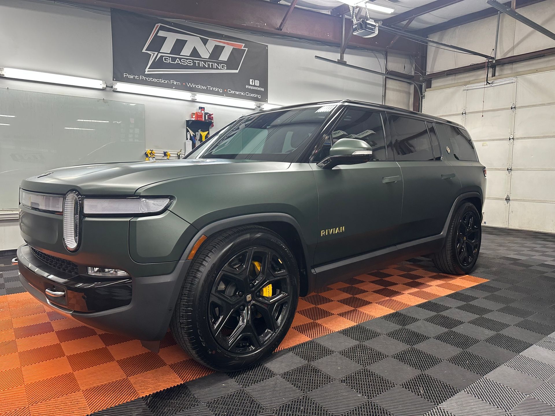 A green suv is parked in a garage.