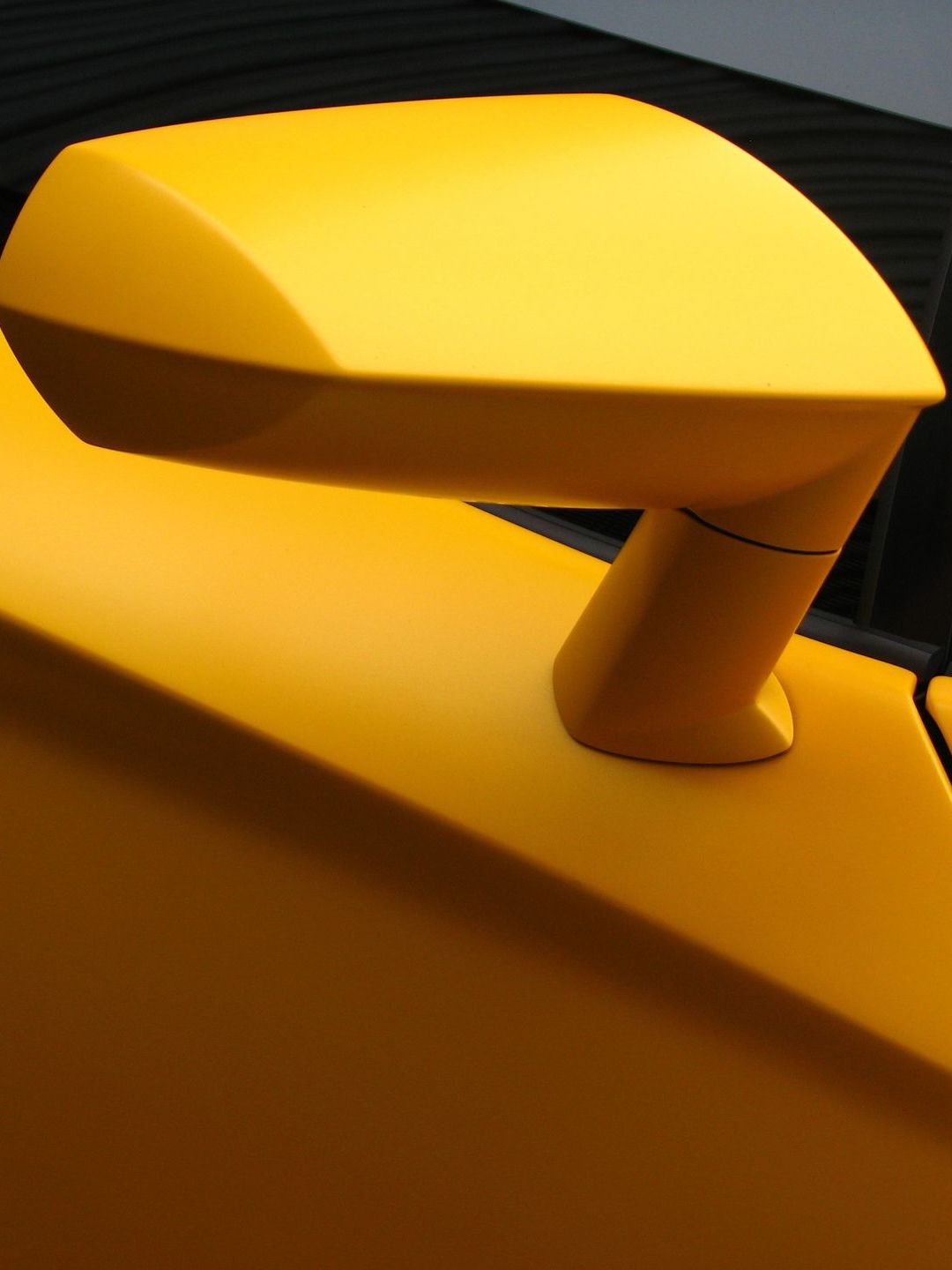 A car with the hood open is sitting on a lift in a garage.