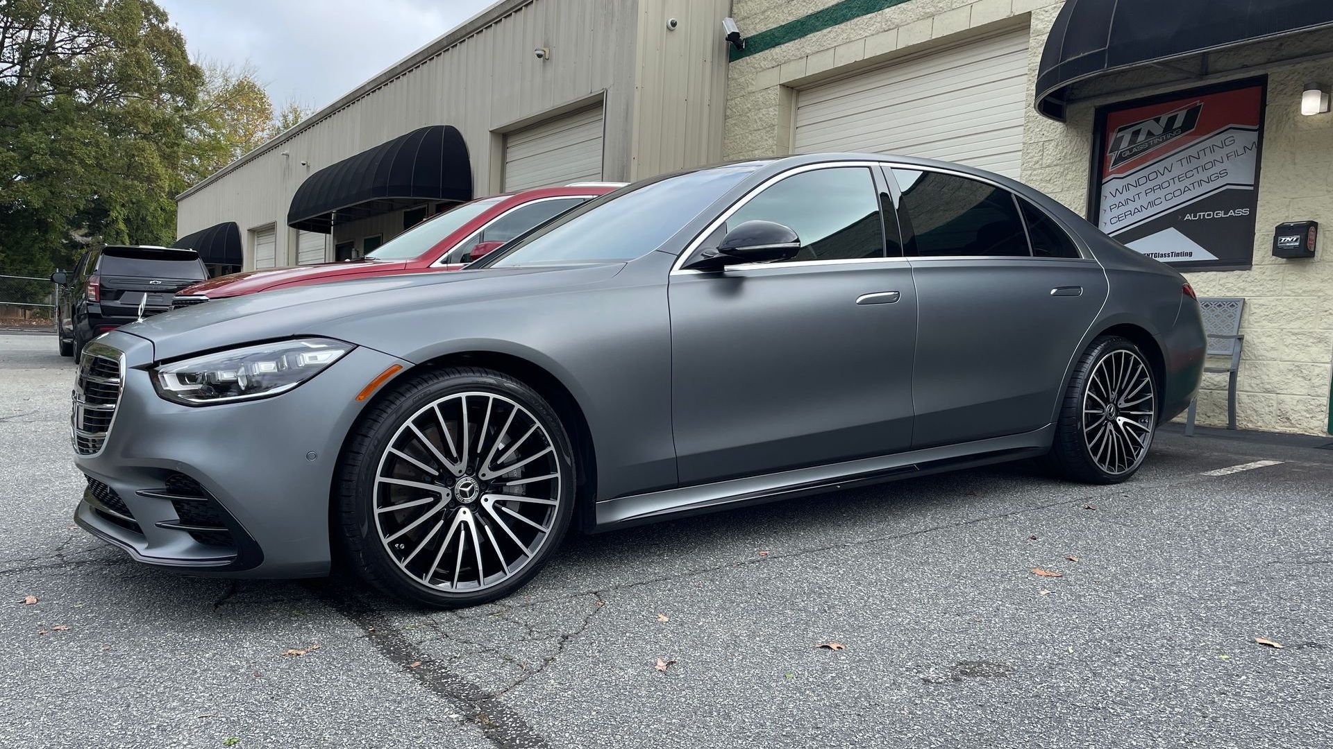 A mercedes benz s class is parked in front of a building.