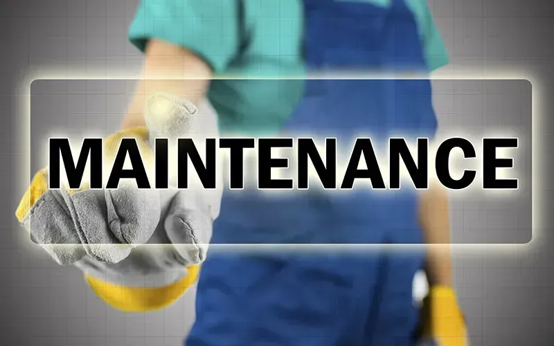 A man wearing gloves is pointing at the word maintenance.