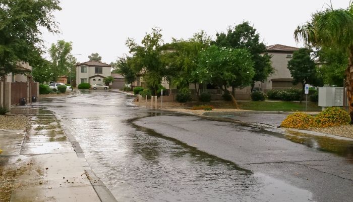 A rainy day in a residential neighborhood with a lot of water on the ground.
