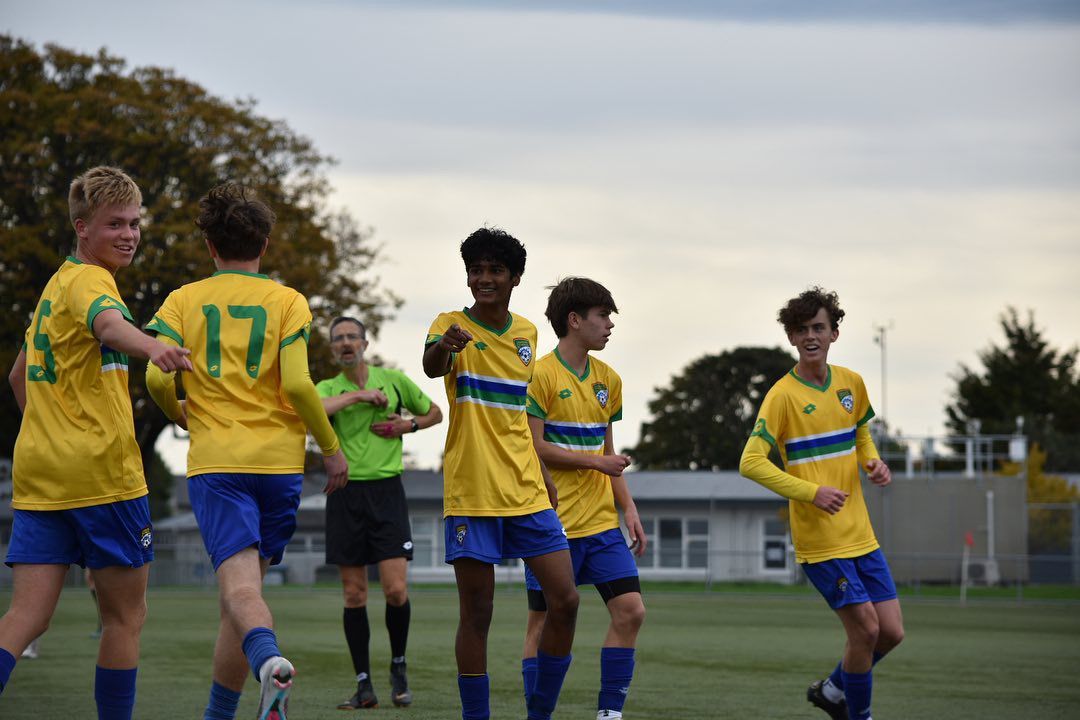 A group of young men are playing soccer on a field.