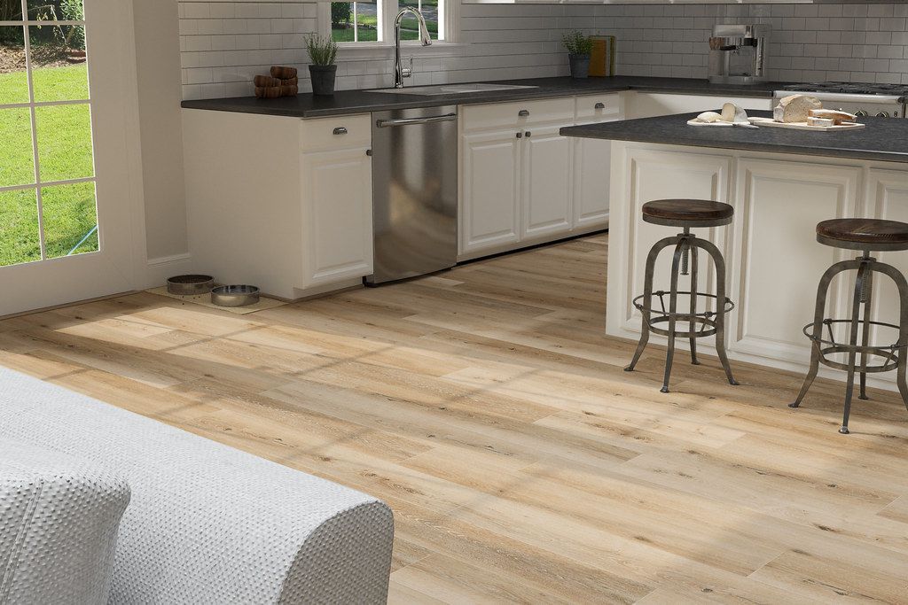 A kitchen with a wooden floor and white cabinets and stools